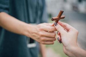 mano con cruz. concepto de esperanza, fe, cristianismo, religión, iglesia en línea. foto