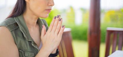 Asian woman praying morning outdoor, Hands folded in prayer concept for faith, spirituality and religion, Church services online concept. photo