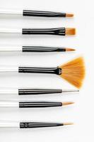 Various new makeup brushes on white photo