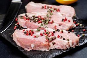 Fresh pork steaks with a mix of peppers peas, close -up