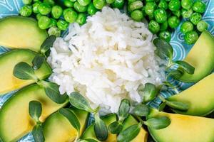 Closeup white rice with avocado, green peas and sunflower microgreen photo
