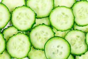Vegetable background with sliced cucumbers photo