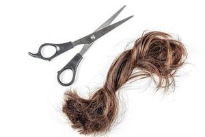 un manojo de pelo cortado con tijeras sobre un fondo blanco. corte de pelo, cambio de concepto