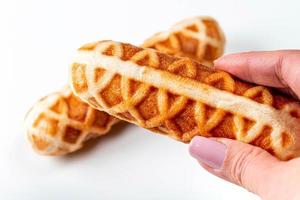 Corn dog in a waffle close-up in a female hand photo