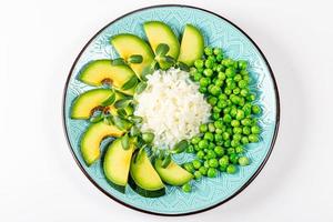 Top view rice with avocado, green peas and sunflower microgreen on a white background
