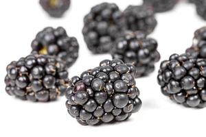 Black berries of ripe blackberries on a white background photo