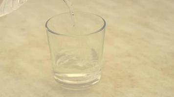 el agua pura de la botella se vierte en el vaso. video