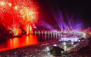 juerguistas, tanto locales como turistas, disfrutan de los impresionantes fuegos artificiales de año nuevo a lo largo de la playa de copacabana, río de janeiro, brasil