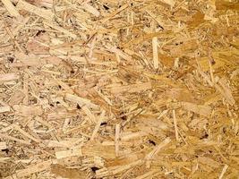 Compressed chipboard background. Wooden plank backdrop. OSB texture photo