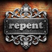 repent word of iron on wooden background photo