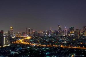 paisaje urbano de rascacielos con luces encendidas en las oficinas por la noche foto