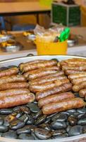 Grilled sausages on hot stones Thai market China Town Bangkok. photo