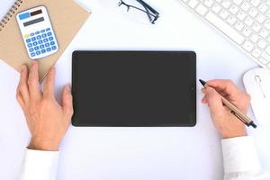 Blank tablet screen while typing on a keyboard, as well as a screen mockup for further customization, can be used for a variety of purposes. area for copying photo