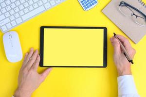 Blank tablet screen while typing on a keyboard, as well as a screen mockup for further customization, can be used for a variety of purposes. area for copying photo