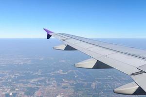 Wing of the plane flying above the city. View from the window of an airplane photo