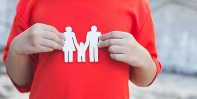 manos de los niños sosteniendo una familia modelo pequeña, familia conceptual foto