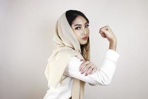 Gorgeous strong young Muslim woman isolated over white background wall showing biceps. photo