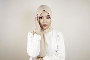 Tired beautiful Asian Muslim girl wearing a headscarf stressed out. photo