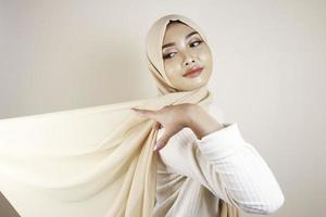 Muslim woman wearing traditional wear and hijab isolated on white background. Hijab is creatively made flying. Idul Fitri and hijab fashion concept.