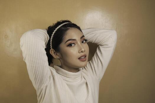 bastante joven mujer asiática atándose el pelo. cuidado del cabello. concepto de belleza. foto