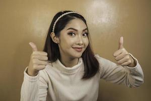 Young Asian woman is selfie with happy smiling face and ok sign on near of mouth look at the camera photo