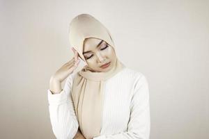 Tired beautiful Asian Muslim girl wearing a headscarf stressed out. photo