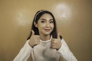 Young Asian woman is selfie with happy smiling face and ok sign on near of mouth look at the camera photo