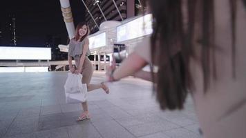 Aziatische vrouwelijke shopper voelt zich gelukkig met het maken van een foto in het centrum van de stad, vriend met behulp van telefooncamera, middernacht promotieverkoop, boodschappentas, vrouwelijke vriendschap, vrouwen machtigen, reizen in Azië stad video