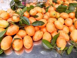 Group of fresh yellow Thai fruit with green leaves. photo