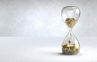 Gold coin in the hourglass, Time is money concept photo