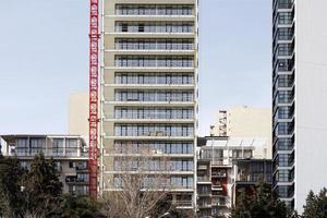 modernos edificios residenciales de varios pisos y una grúa de elevación roja. foto
