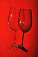 Minimalist still life, wine glass on red background with creative shadow. photo