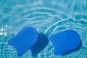 tablero de espuma azul para enseñar a nadar junto a la piscina foto