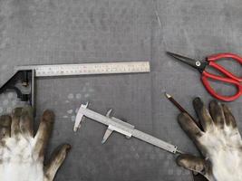 guantes sucios y vernier en taller, equipo mecánico foto