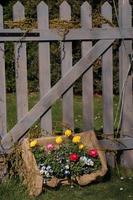 Crate of flowers in front of a picket fence
