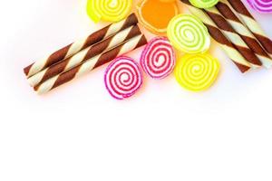 dulces coloridos y caramelos de azúcar en un fondo blanco foto
