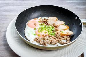 Pan-fried egg with toppings, hot breakfast in cooking served on table in morning. photo