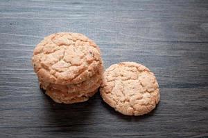 Delicious oatmeal cookies on dark wooden table. photo