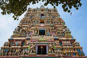 Traditional Hindu temple Kidangamparambu Sree Bhuvaneswari in India in Allapuzha Allepi Kerala. Tall building with colorful figures of Indian mythology and gods, flock of live birds. Tourism, travel photo