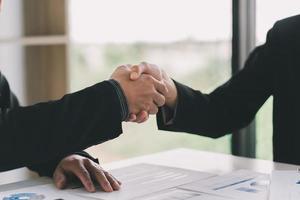 Close up view of business partnership handshake.Concept two businessman handshaking process.Successful deal after great meeting.Horizontal,flare effect, blurred background.