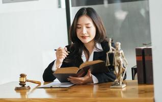 abogadas abiertas y leyendo con un libro de leyes en su lugar de trabajo. foto