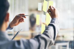 Business people meeting at office and use post it notes to share idea. Brainstorming concept. Sticky note on glass wall. photo