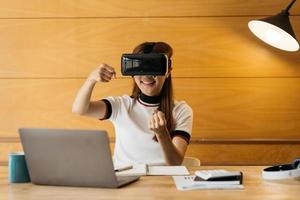 Woman wearing virtual reality goggles standing in a office. VR glasses. 360 degrees. Virtual reality headset. VR game. Wearing virtual reality goggles. Smartphone with VR. Virtual reality video. photo