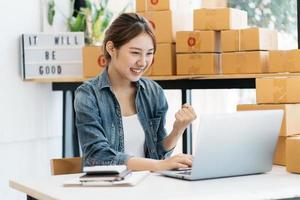 Starting Small business entrepreneur SME freelance,Portrait young woman working at home office, BOX,smartphone,laptop, online, marketing, packaging, delivery, SME, e-commerce concept photo