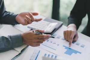 primer plano de empresarias sentadas en la mesa y discutiendo el contrato comercial durante la reunión de negocios foto