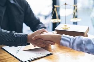 Businessmen shaking hands above the wooden desk in a modern office, close up. Unknown business people at meeting. Teamwork, partnership and handshake concept. photo