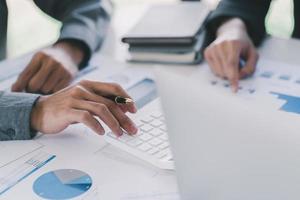 Two business people discuss meeting targets sitting at the business table with documents photo