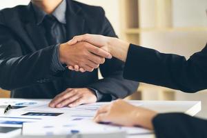 Close up view of business partnership handshake.Concept two businessman handshaking process.Successful deal after great meeting.Horizontal,flare effect, blurred background. photo