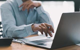 la mano de negocios presionando el teclado de la computadora portátil, el mundo de la tecnología y la comunicación por Internet, los profesionales financieros usan la computadora portátil para calcular y verificar las ganancias de bienes raíces. foto