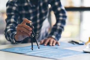 Architect and engineer meeting Planning for a New Project with construction equipment on table, Architect and engineer working with blueprint. photo